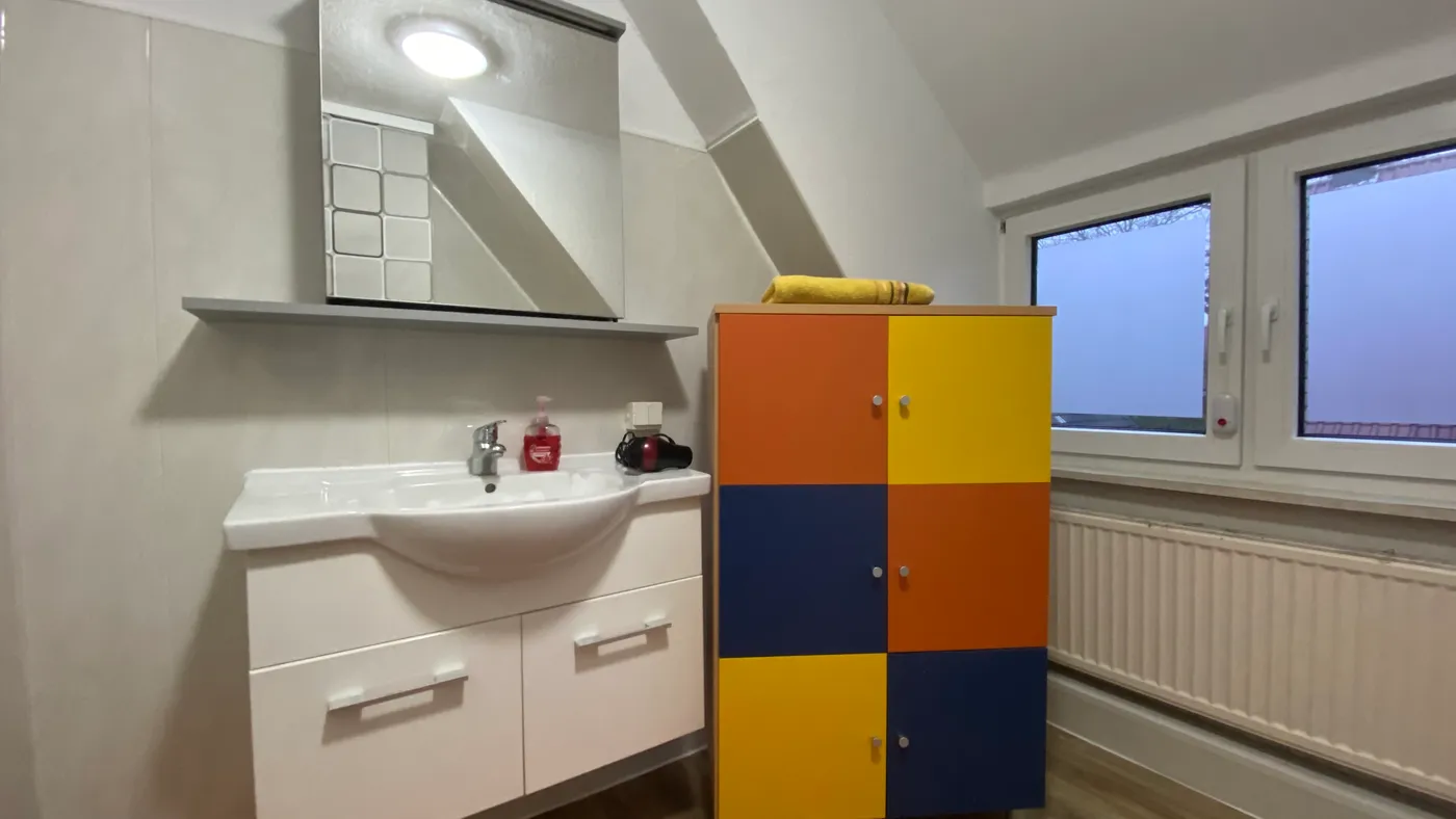 Badezimmer mit Waschtisch und buntem Schrank